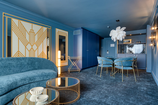 Vue du salon raffiné de la Suite Gatsby, avec mobilier élégant, ambiance glamour et décoration inspirée des années folles, idéal pour un séjour romantique à Liège.